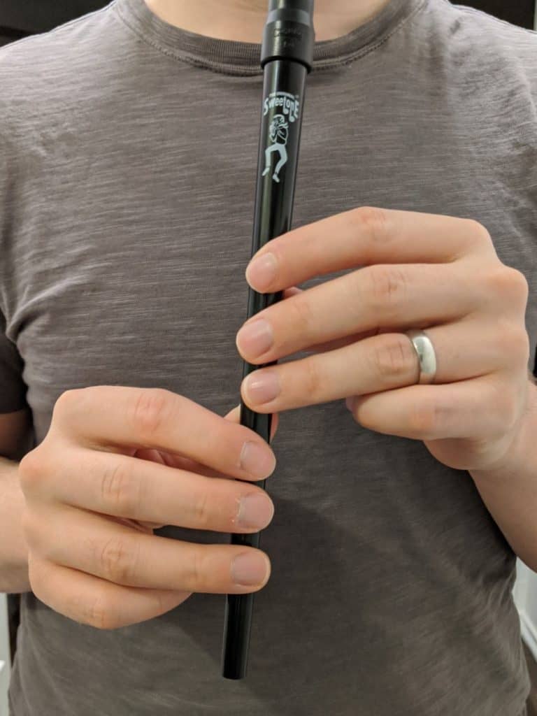 me holding a tin whistle with all the finger holes covered